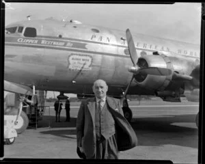 Passenger Alfred Taylor, having arrived on a Pan American World Airways flight, stands in front of Douglas DC-4 Clipper Westward Ho (N88948) at Whenuapai aerodrome, Waitakere City, Auckland