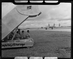 Staff at Kallang Airport, Singapore, sit on Qantas Empire Airways airstairs and watch the departing Lockheed L749-79 Constellation (VH-EAB) aircraft Lawrence Hargrave, which taxis on the runway