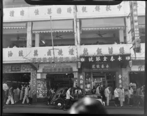 Busy street scene, Hong Kong, featuring Chun Hing Co (Bakers and Confectioners) and Wing Tai Bank