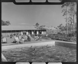 Unidentified family group [including nanny?] around and in the swimming pool at the Qantas Empire Airways Lounge, Darwin, Northern Territory, Australia