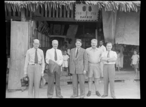 Auckland travel agents, George Brough second from left, standing outside a Barber's shop in Labuan, Malaysia