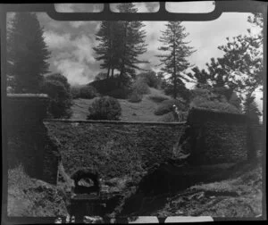 Unidentified man looking over a stone walled culvert, Norfolk Island