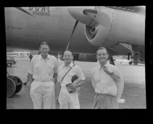 Qantas Empire Airways staff members E Kidd, Neil Geikie and G Hodge, stand in front of a British Overseas Airways Corporation aircraft at Kai-Tak Airport, Kowloon, Hong Kong