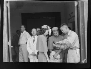 Unidentified crowd, including airline staff, outside the waiting room for departing passengers [Kai-Tak Airport, Kowloon, Hong Kong?]