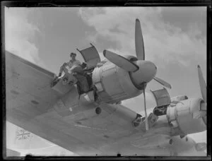 Men working on the engine of the Tasman Empire Airways Ltd Solent aircraft, Mechanics Bay, Auckland