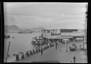 Hong Kong waterfront scene including hand drawn rickshaws, ferry terminal, [Kowloon Star ferry?] and boats at sea, Hong Kong