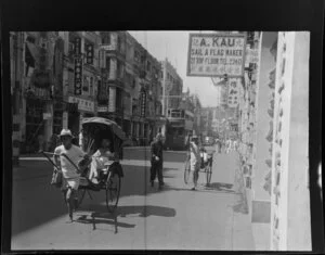 Street scene, Aberdeen, Hong Kong, including hand drawn rickshaws, a double-decker tram and businesses such as A Kau Sail and Flag Maker
