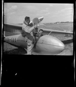 Unidentified man standing next to Mr G Hookings in his glider, ZK-GAA at Mangere, Auckland