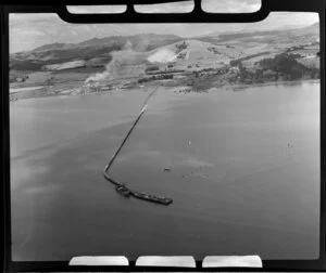 Coastal scene, Portland, Whangarei District, Northland Region, featuring wharf, cement works, and limestone quarry