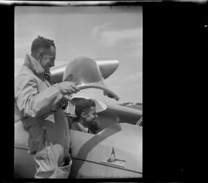 Unidentified man standing next to Mr G Hookings in his glider, ZK-GAA at Mangere, Auckland