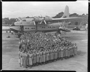 Group of Tasman Empire Airways Ltd staff standing alongside the Solent IV flying boat RMA Awatere, ZK-AMN