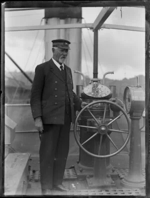 Captain Edward McLeod at the helm of the Northern Steam Ship Company Limited paddle steamer Wakatere