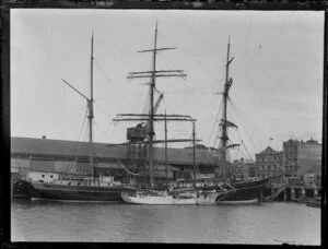 Unidentified three-masted sailing ship and smaller yacht docked at an Auckland City wharf, Waitemata Harbour, including Robertson building
