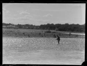 Fisherman fishing for trout in unidentified river