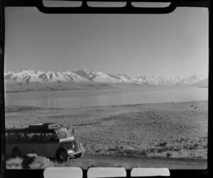 Mt Cook and Southern Lakes Tourist Company Ltd bus, including Lake Pukaki and Mt Cook in the background