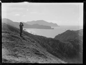 Whaling, featuring an unidentified man standing on a headland and searching for whales with binoculars, Bay of Islands, Far North District, Northland Region