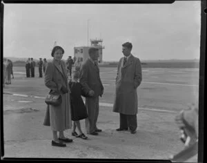 Captain Bradshaw with his wife and son talking to an unidentified man on the arrival of Captain Bradshaw at Whenuapai airport