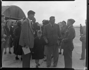 Captain Bradshaw with his son talking to two unidentified men on the arrival of Captain Bradshaw at Whenuapai airport