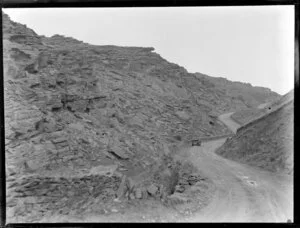 A car on an unsealed road winding through rocky hills outside Alexandra, Central Otago