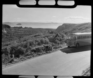 Landliner coach on road beside Lake Taupo