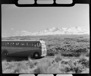 Landliner coach travelling through Tongariro National Park with Mount Ruapehu in the background