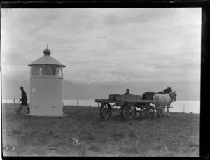 Kaikoura lighthouse with two unidentified men and a cart and horses beside it