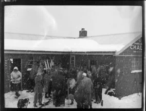 Skiers gathered around outside the Happy Valley Chalet during a snowfall while skiing on Coronet Peak, Otago