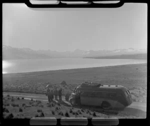 Group beside a Mount Cook and Southern Lakes Tourist Co coach looking at Lake Pukaki, MacKenzie District