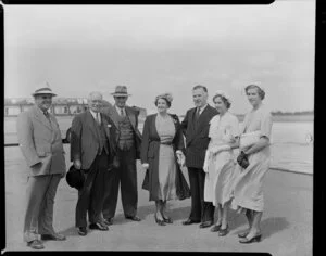 Prime Minister Sidney Holland arriving at Whenuapai Airport, Auckland, with his family and unidentified group of men