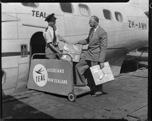 Presentation of promotional film reels to a representative of New Zealand Forest Products by a TEAL staff member