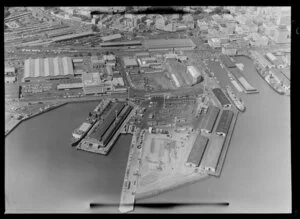 Ships, containers and warehouses on the wharf at Port of Auckland, Waitemata Harbour, including industrial area, Railway Station and City