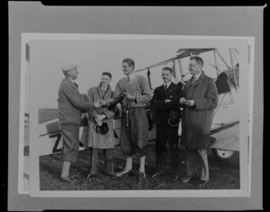 Copy photograph of a group of men standing by an aircraft