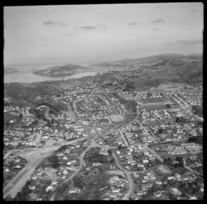 View over the Wellington City northern suburb of Johnsonville with the Southern Motorway under construction, Johnsonville Railway Station and Moorefield Road, to Wellington Harbour beyond