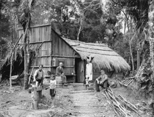 Group outside a thatched wooden hut
