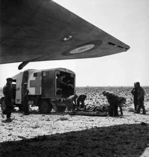 Transferring wounded from motor ambulance to air ambulance during World War II, Tunisia
