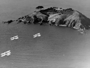 Aerial view of Somes Island with three biplanes flying past