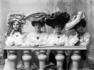 Four women wearing hats