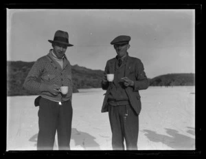 Portrait of two men drinking tea outside, possibly on a frozen lake