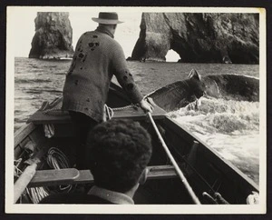 Captain Herbert Cook with unidentified male in boat in pursuit of whale