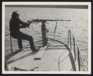 Man standing on modern fast whaling boat with harpoon gun