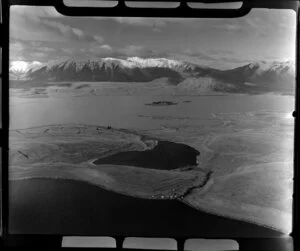 Lake Alexandrina (front), Lake Mcgregor (middle), and Lake Tekapo (back), Mackenzie District, Canterbury Region, including Motuariki Island, small unidentified settlement, and light striking the snowy flank of Mount Dobson