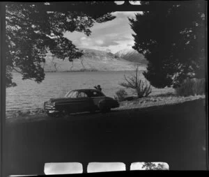 Unidentified man [Harry Wigley?] with a Chevrolet sedan car beside Lake Ohau, Waitaki County