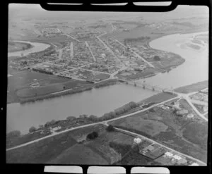 Balclutha, Otago District, showing Barnego Road and outer residential area foreground, and Milton Highway (State Highway 1) with bridge over Clutha River to township with sports grounds and primary school, farmland beyond