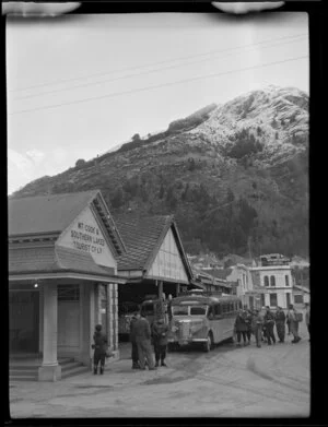 People gathered around a bus parked outside the Mt Cook and Southern Lakes Tourist Company office in Queenstown