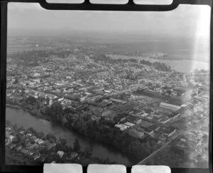 Hamilton, Waikato District, showing Waikato River with railway bridge, looking over Victoria Street toward Lake Domain Reserve and Lake Rotoroa, farmland beyond