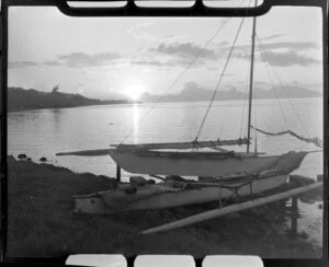 Papeete sunset, Tahiti, showing sail boat on land in foreground