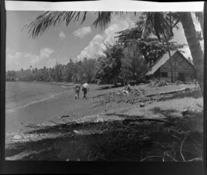 Royal Tahitian beach, Tahiti, showing people walking along beach, palm trees and a hut