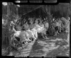 Tourists sit and relax while at a ceremony feast, Tahiti