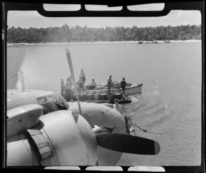 TEAL (Tasman Empire Airways Limited) Flying boat refuelling, Akaiami, Aitutaki, Cook Islands, showing men in boats with barrels of fuel