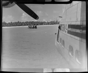 Men on boat with barrels of fuel for TEAL (Tasman Empire Airways Limited) Flying boat, Akaiami, Aitutaki, Cook Islands